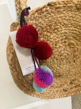 Le Papillon jute purse with Red and Multicolor Pom-Pom Bag Charm.